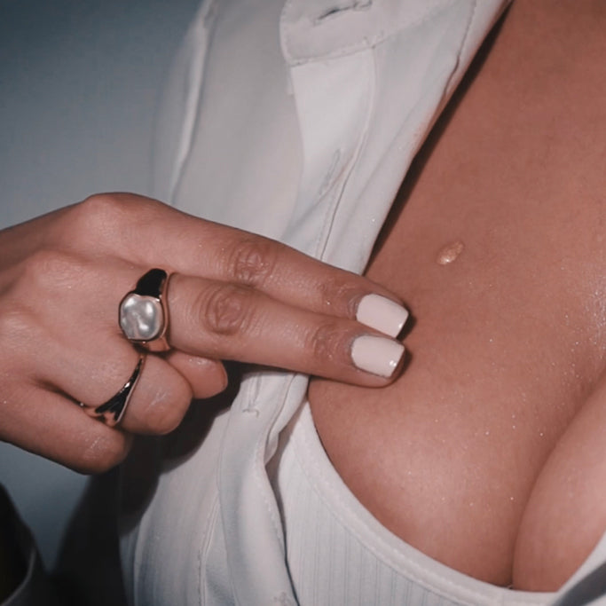 Woman applying luxury Boustise Breast Enhancement Serum Cream to glowing skin